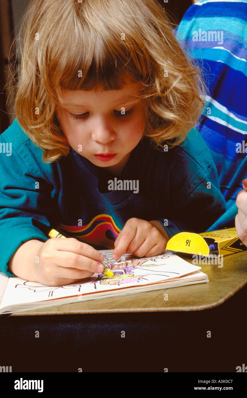 Girl age 3 drawing in coloring book with crayons. Western Springs
