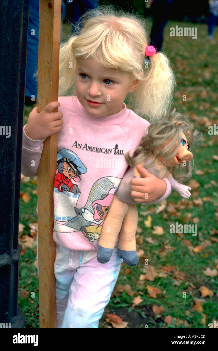 Girl with Miss Piggy doll at Catholic School bike-a-thon age 3. St Paul Minnesota USA Stock Photo