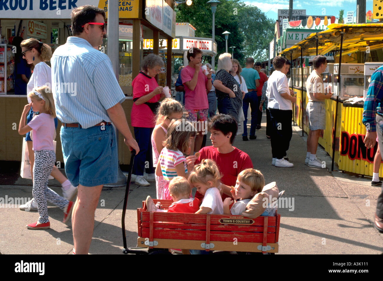 Family talking and traveling by wagon ages 1 through 6. State Fair St Paul Minnesota USA Stock Photo