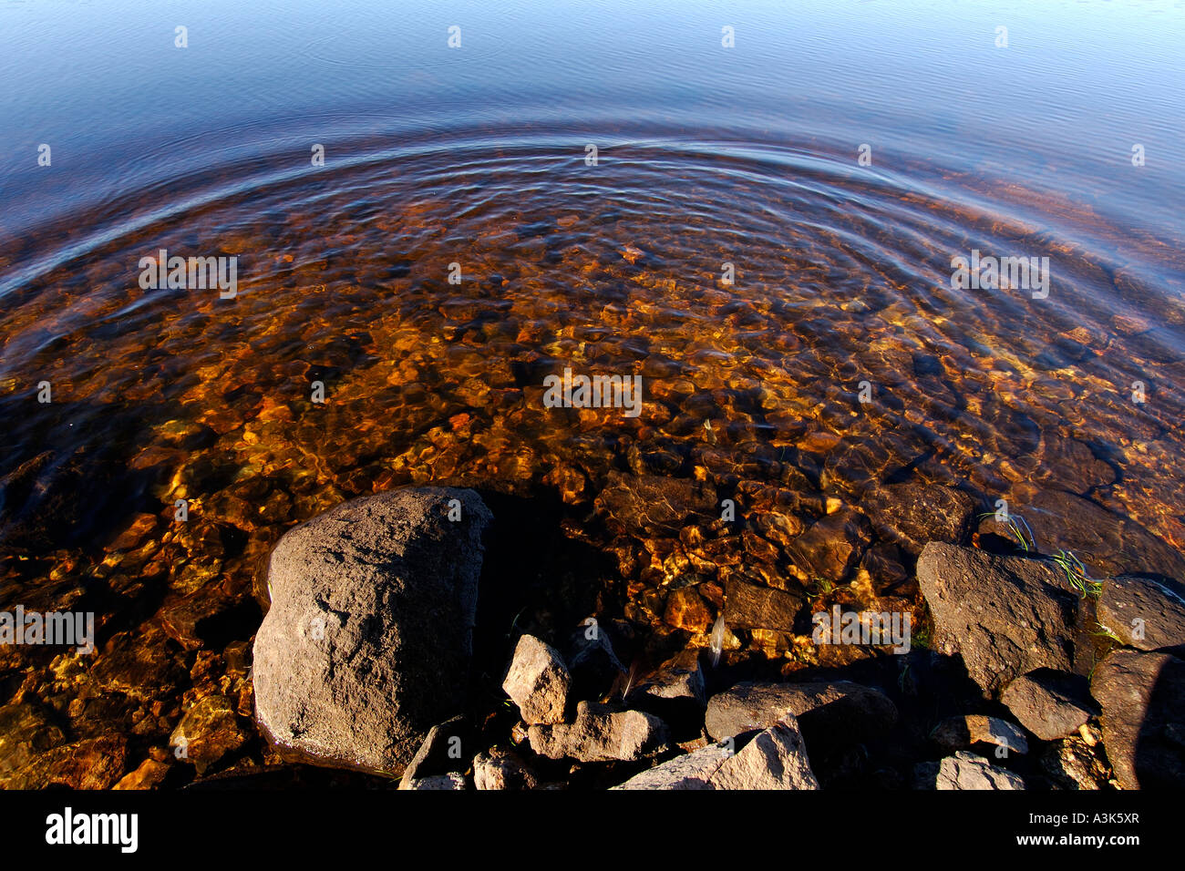 Abstract image of graduated colours on the surface of a reservoir with semi circular ripples Stock Photo