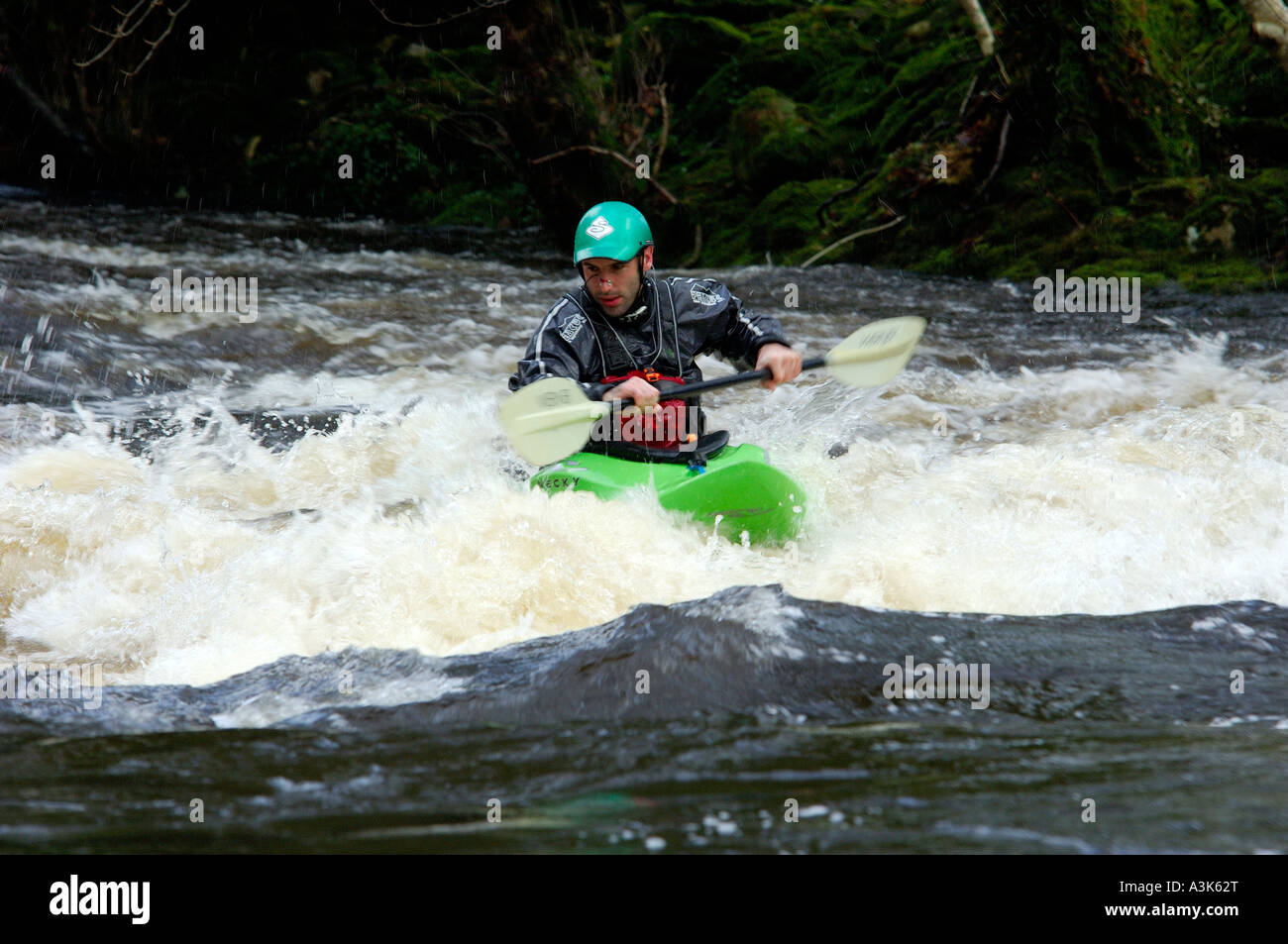 Canoeist on white water on the River Dart in South Devon battling against the force of the river Stock Photo