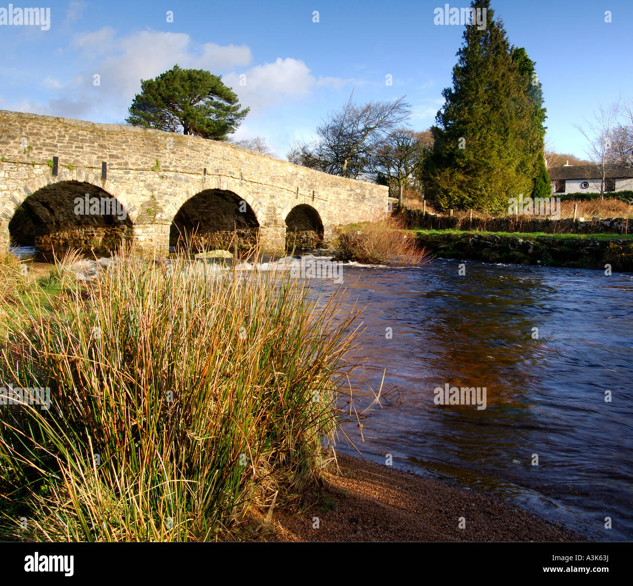 Village of Postbridge Dartmoor showing newer stone road bridge crossing East Dart river flowing beneath Stock Photo