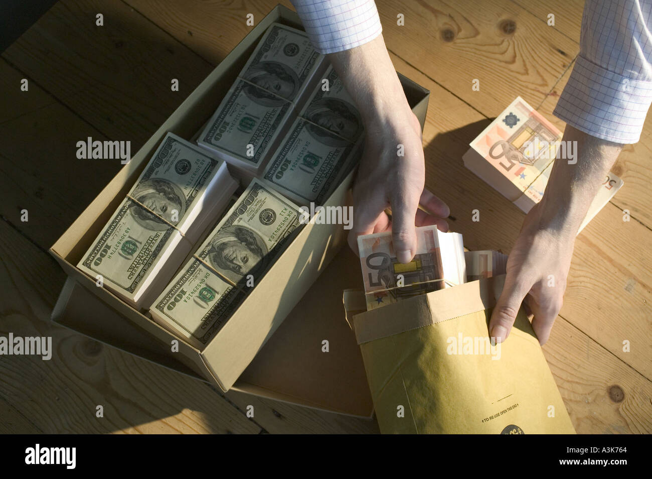 Shoe box of dollar bill and man with package of sterling banknotes ...