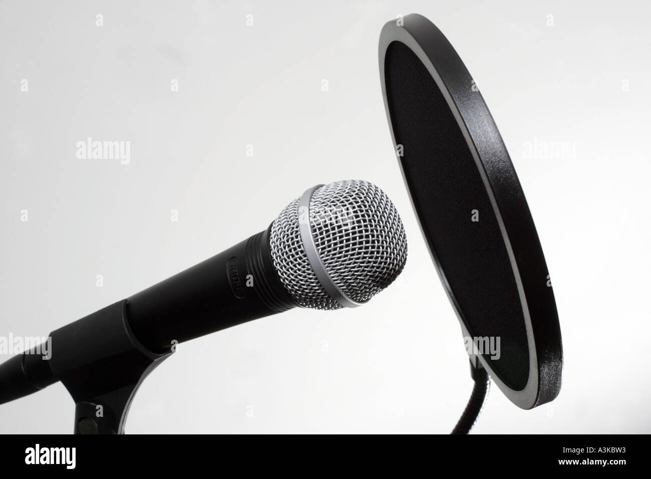 A Shure dynamic microphone on a stand fitted with a pop screen Stock