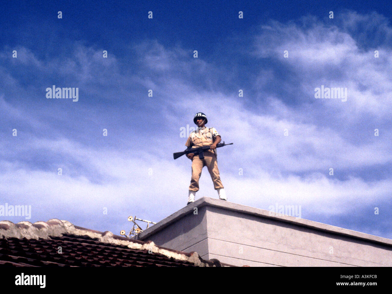 Military policeman standing guard on rooftop during Carneval parade in Barranquilla Colombia South America Stock Photo