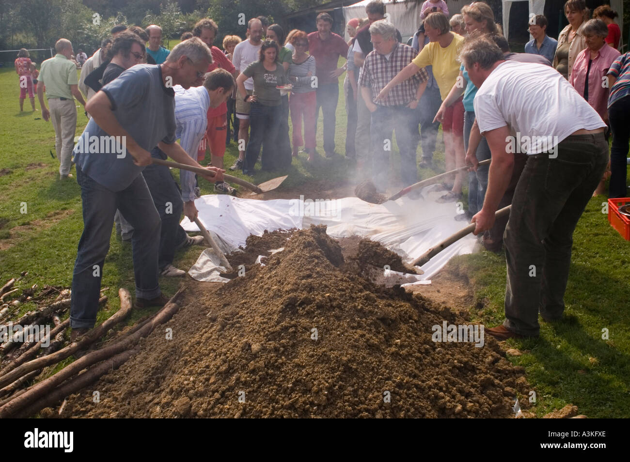 Covering the pit oven at a curanto, cooking in a pit oven, vegetables and meat cooking over hot stones Stock Photo