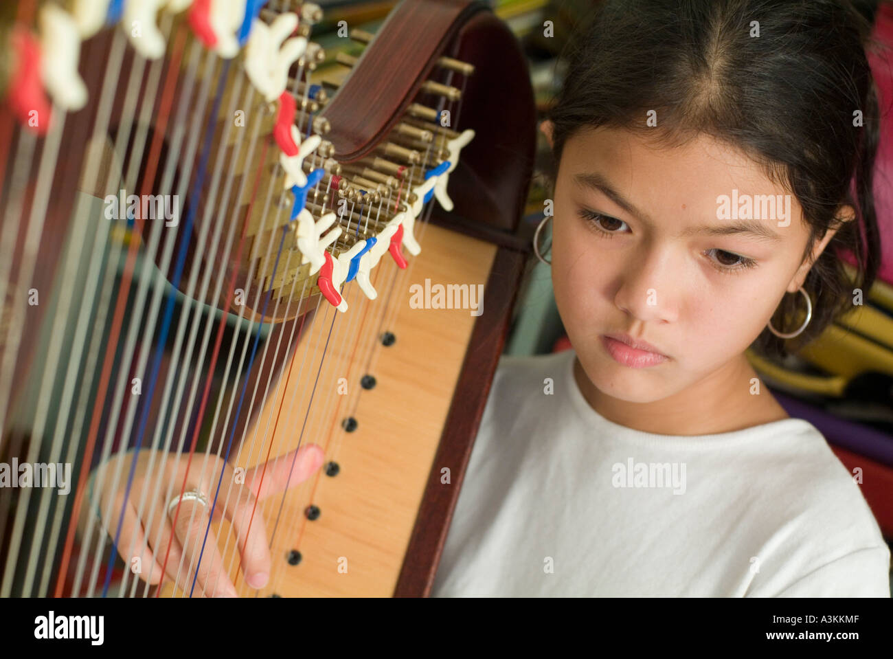 Girl practicing playing the harp at home Stock Photo