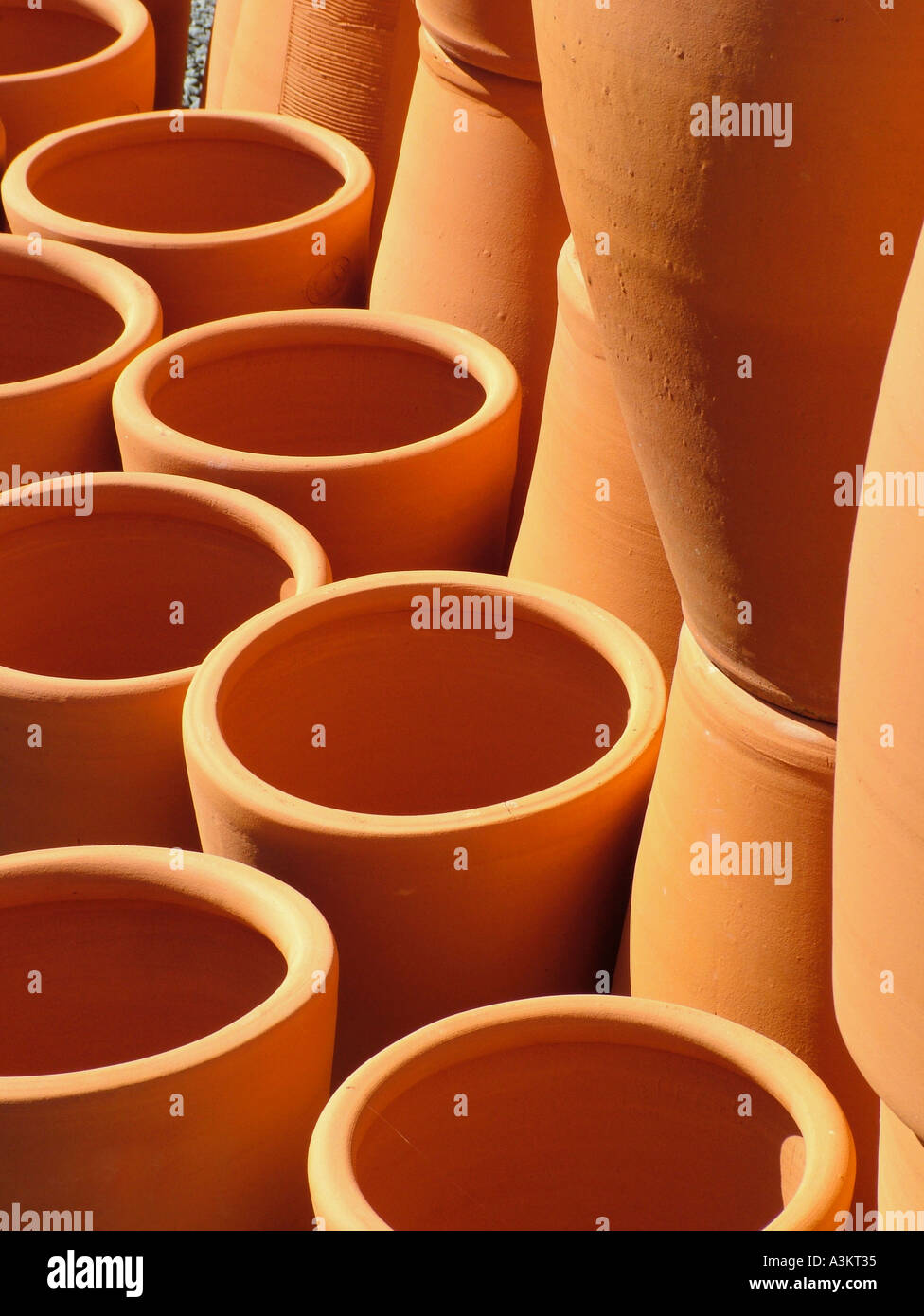 Large terracotta earthenware pots stacked in the sun Morris James