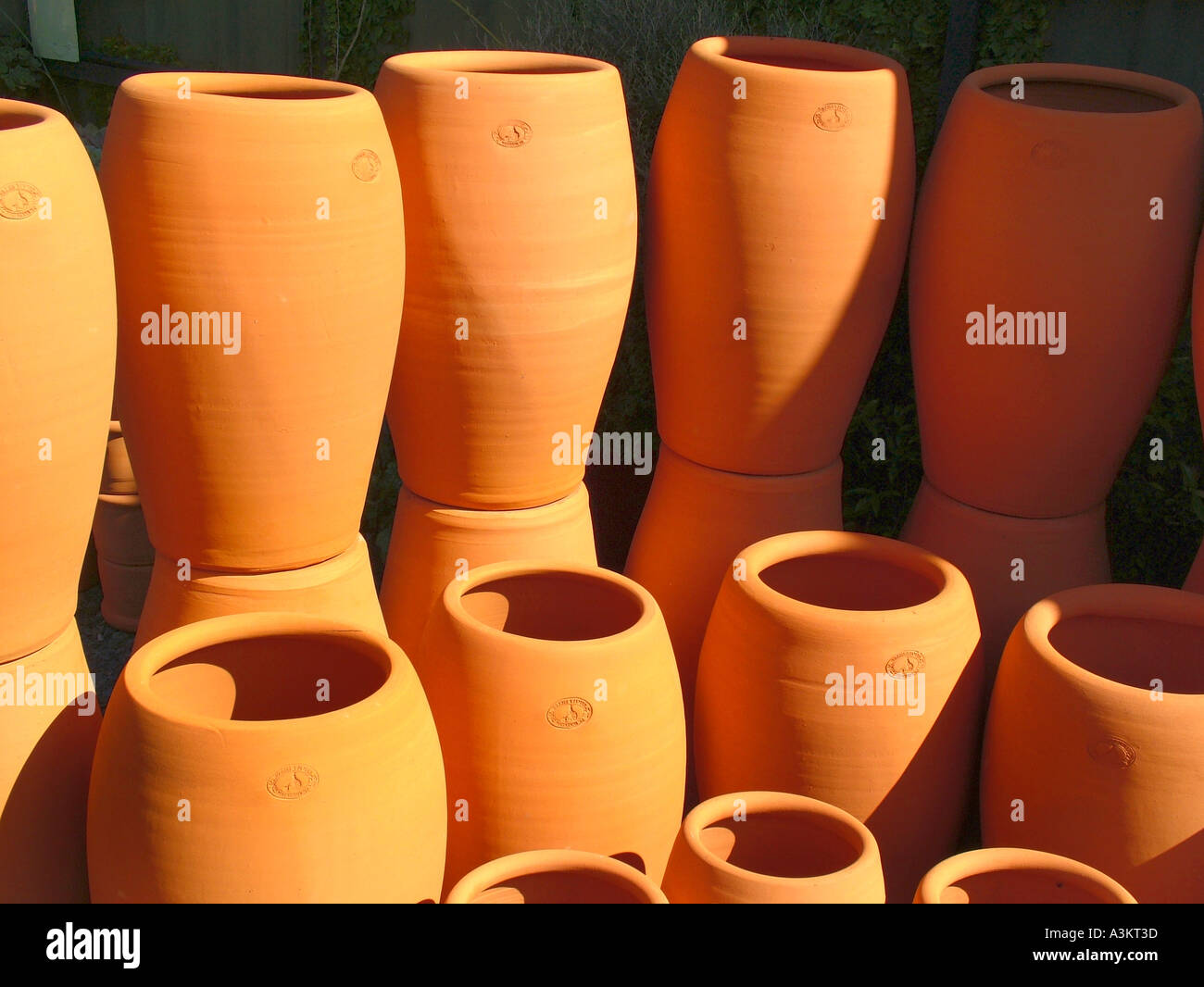Large terracotta earthenware pots stacked in the sun Morris James