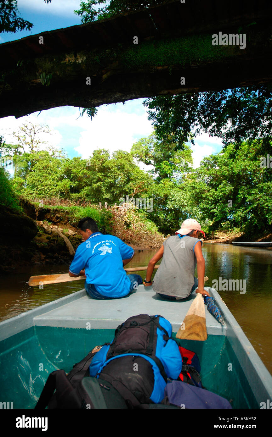 Children Navigating a Boat Passing Under a Bridge on Tortuguero River in Costa Rica Central America Stock Photo