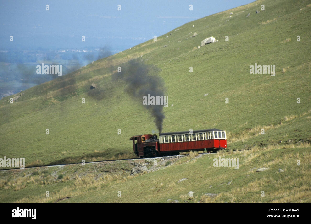 Near Llanberis Snowdon mountain railway steam train on sloping track on way to summit Stock Photo