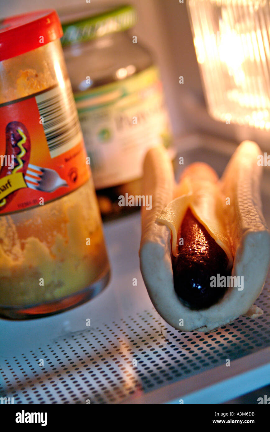 hot dog in refrigerator beneath a glass of mustard Stock Photo Alamy