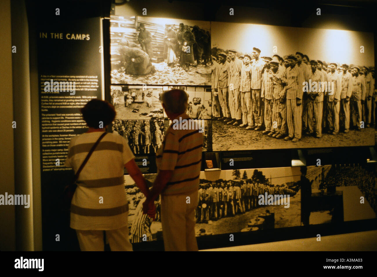 Couple holding hands while viewing display inside the United States Holocaust Memorial Museum Washington DC USA Stock Photo