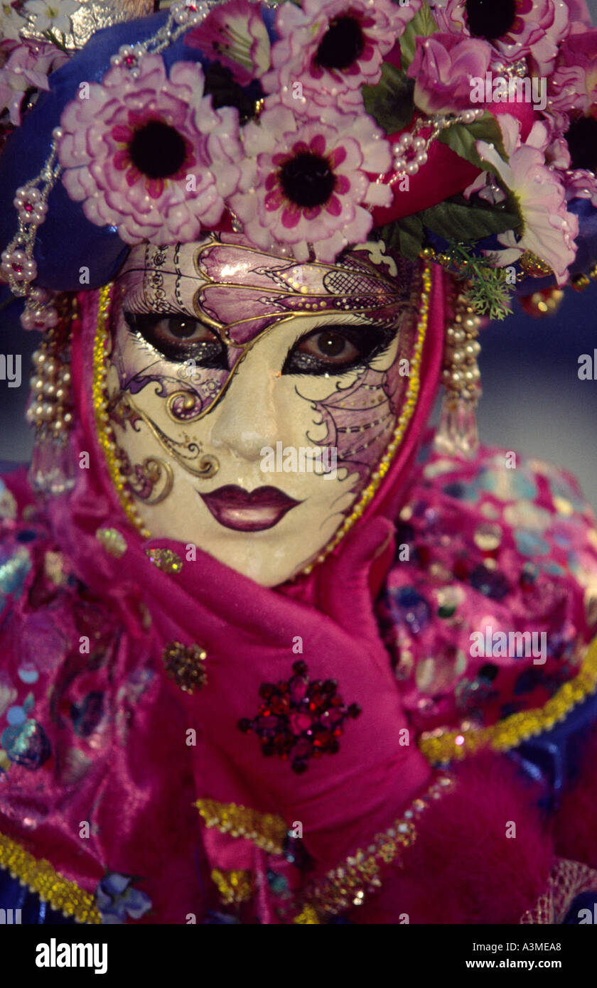 Portrait person in pearly gold mask dressed in floral themed costume at masquerade carnival in Venice Italy Europe Stock Photo