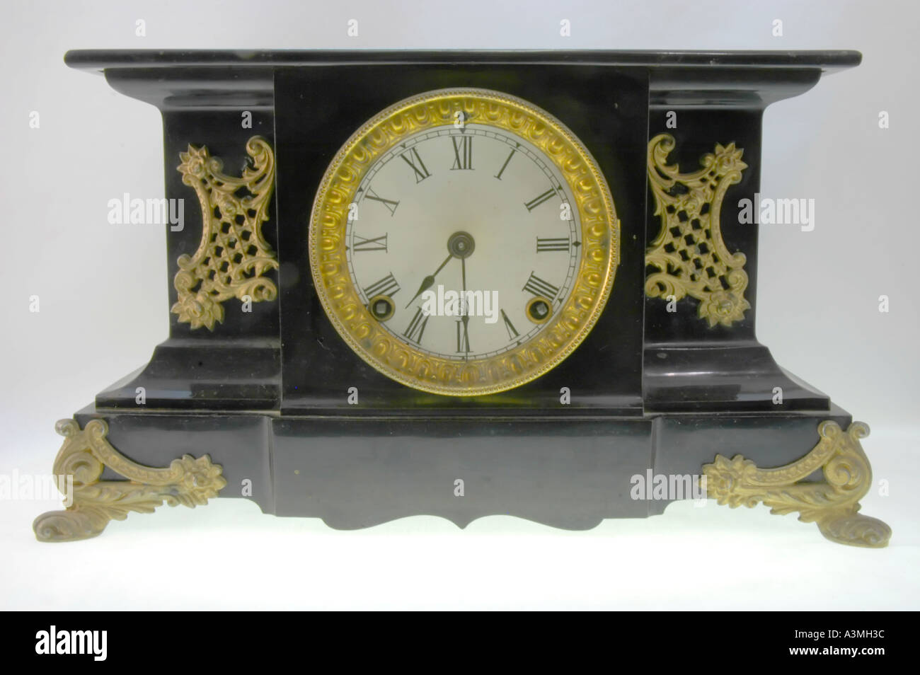 Antique wind up mantle clock with roman numerals on the clock face