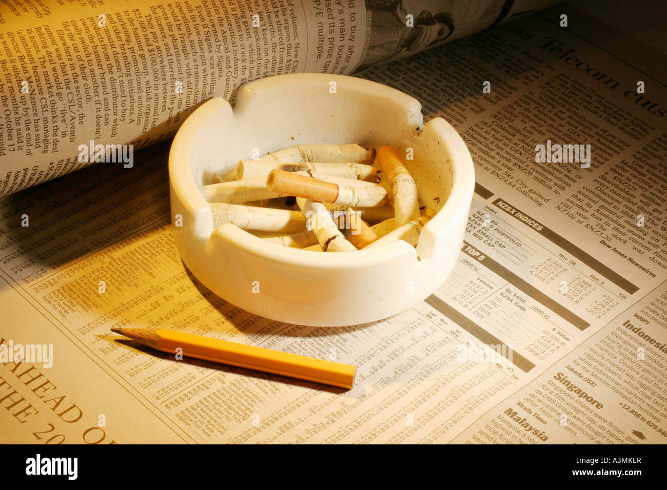 Ashtray and Pencil on  Financial Newspapers Stock Photo