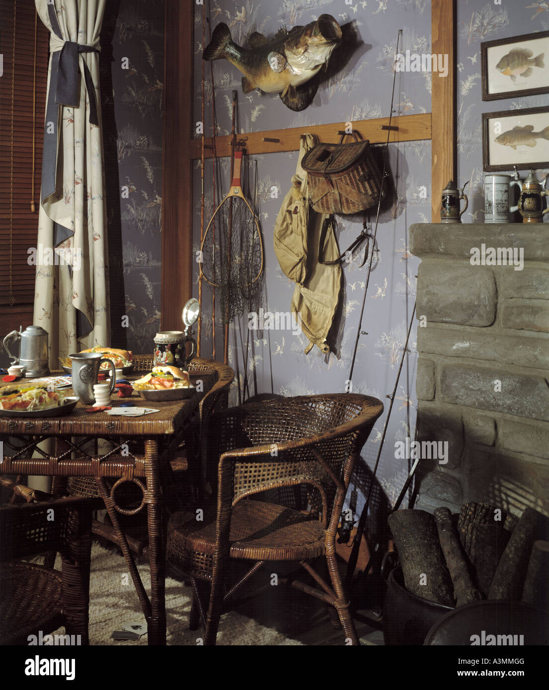 living room stone firplace sportsman fisherman antiquewall wallpaper table  chair stuffed mounted bass fish creel net beer stein Stock Photo - Alamy