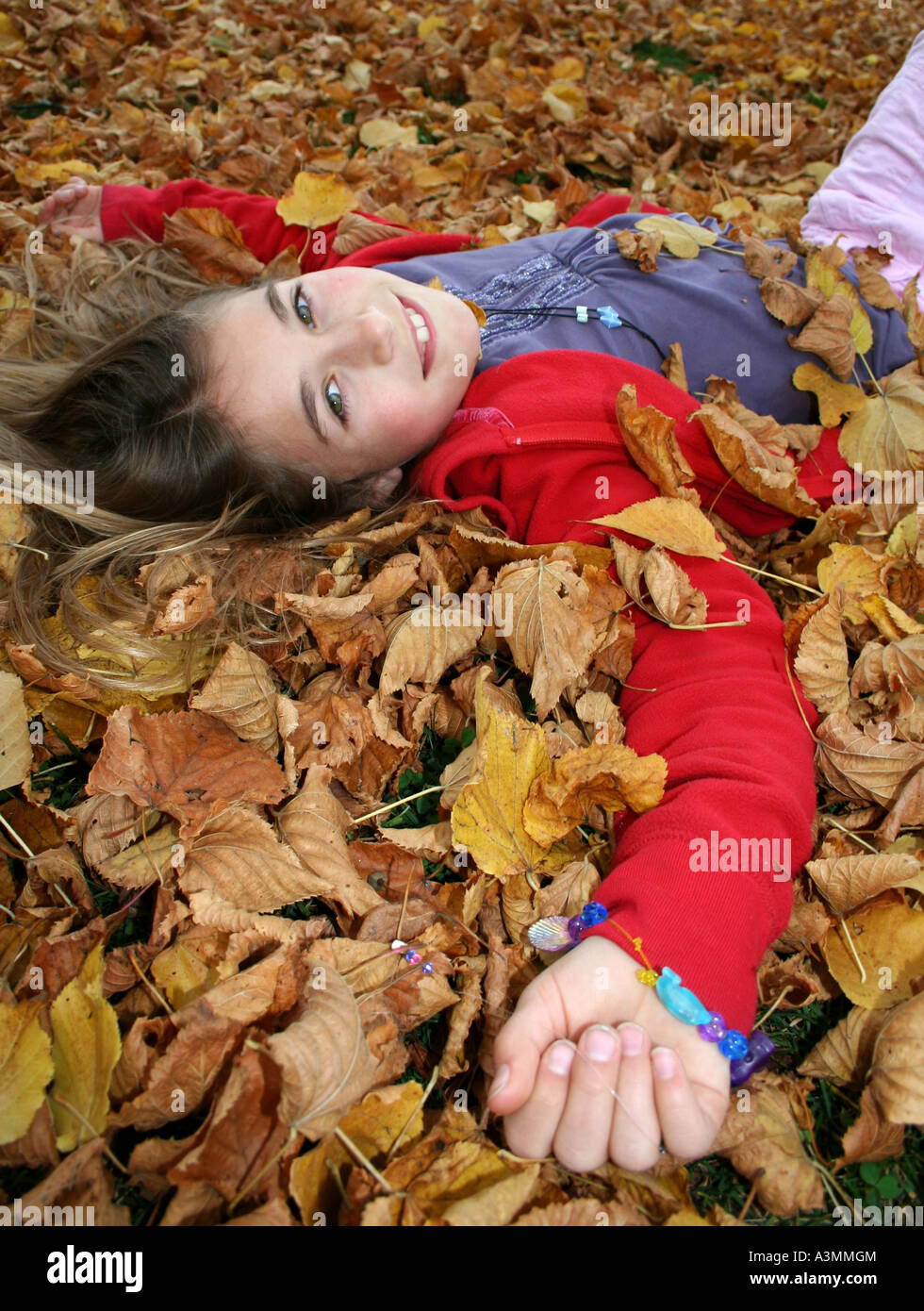close up of young girl lying in autumn leaves Stock Photo - Alamy