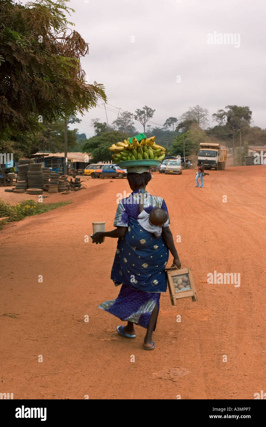 Woman street hawker selling bananas, plantain and snacks with baby on her back, Ghana Stock Photo