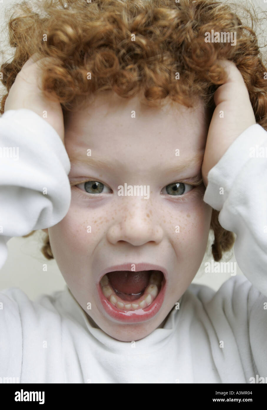 Boy screaming holding his head Stock Photo