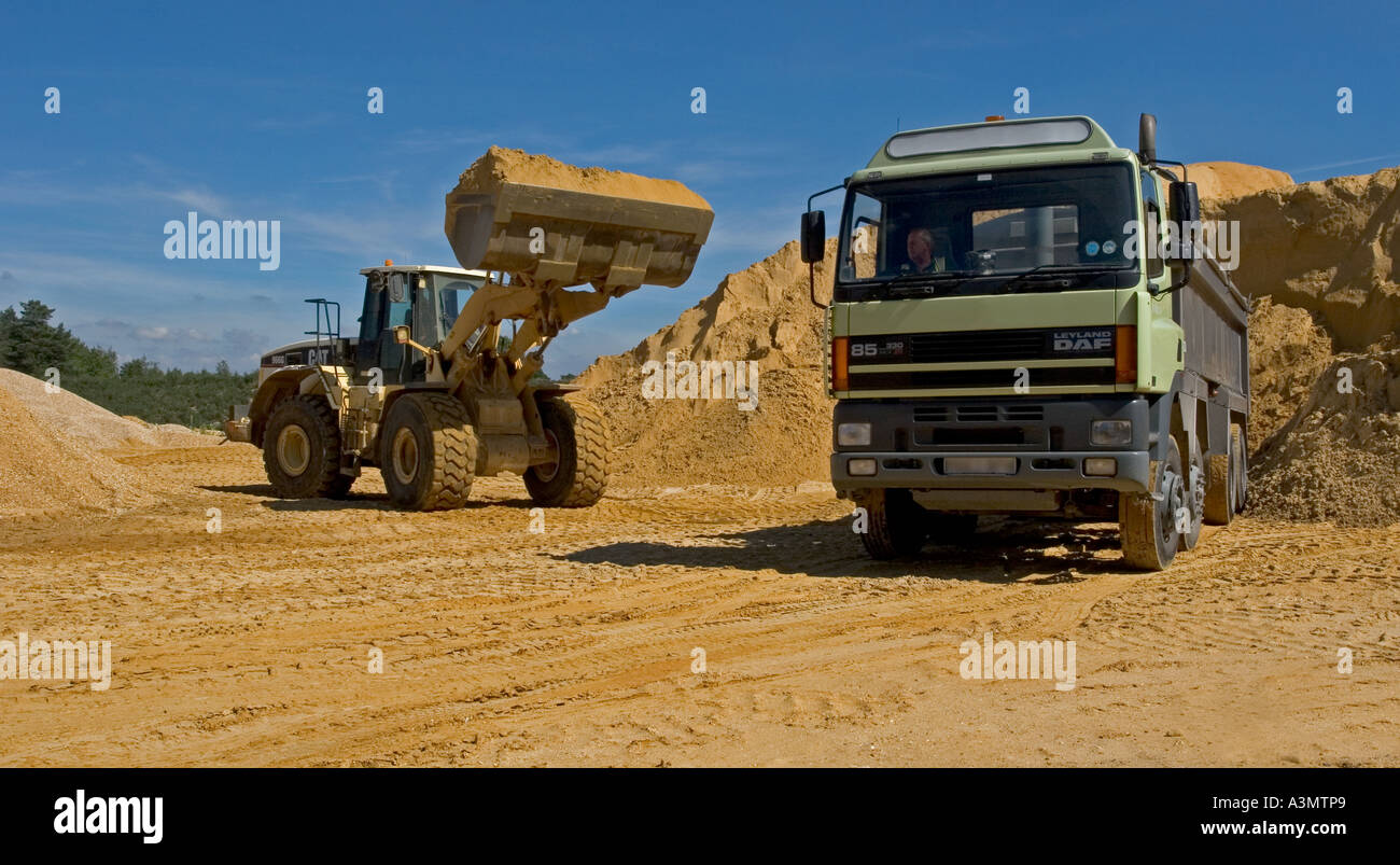 Loading sand into truck from stockpile at quarry for construction purposes Stock Photo