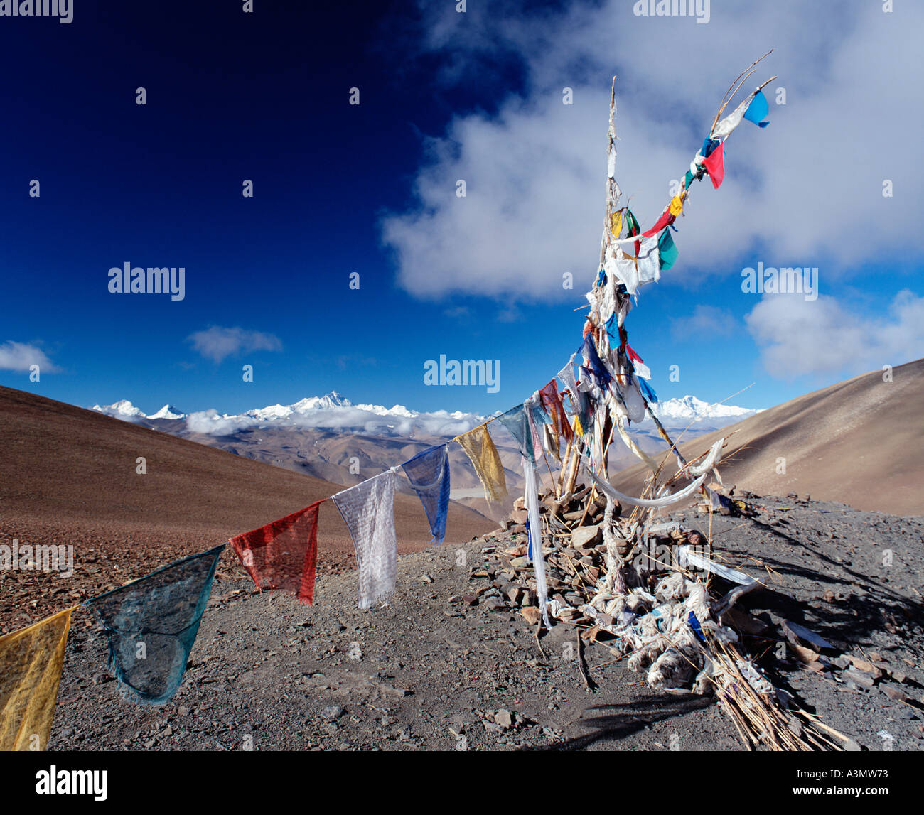 Prayer flags at Pang La Pass with a view of the Himalayas in the Distance with Mt Everest tallest peak centre left Tibet China Stock Photo