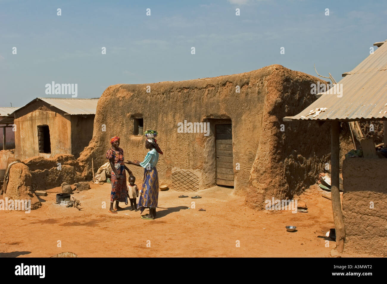 Village women with child Larabanga Ghana showing vernacular architecture with patterned mud walls Stock Photo