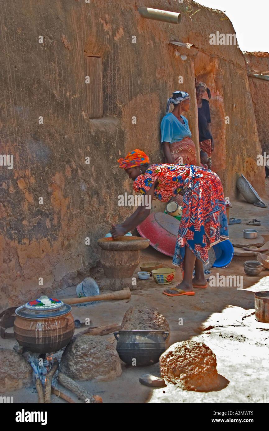Village woman, Larabanga, Ghana, cooking on open fire in the traditional way outside her house built of mud. Stock Photo