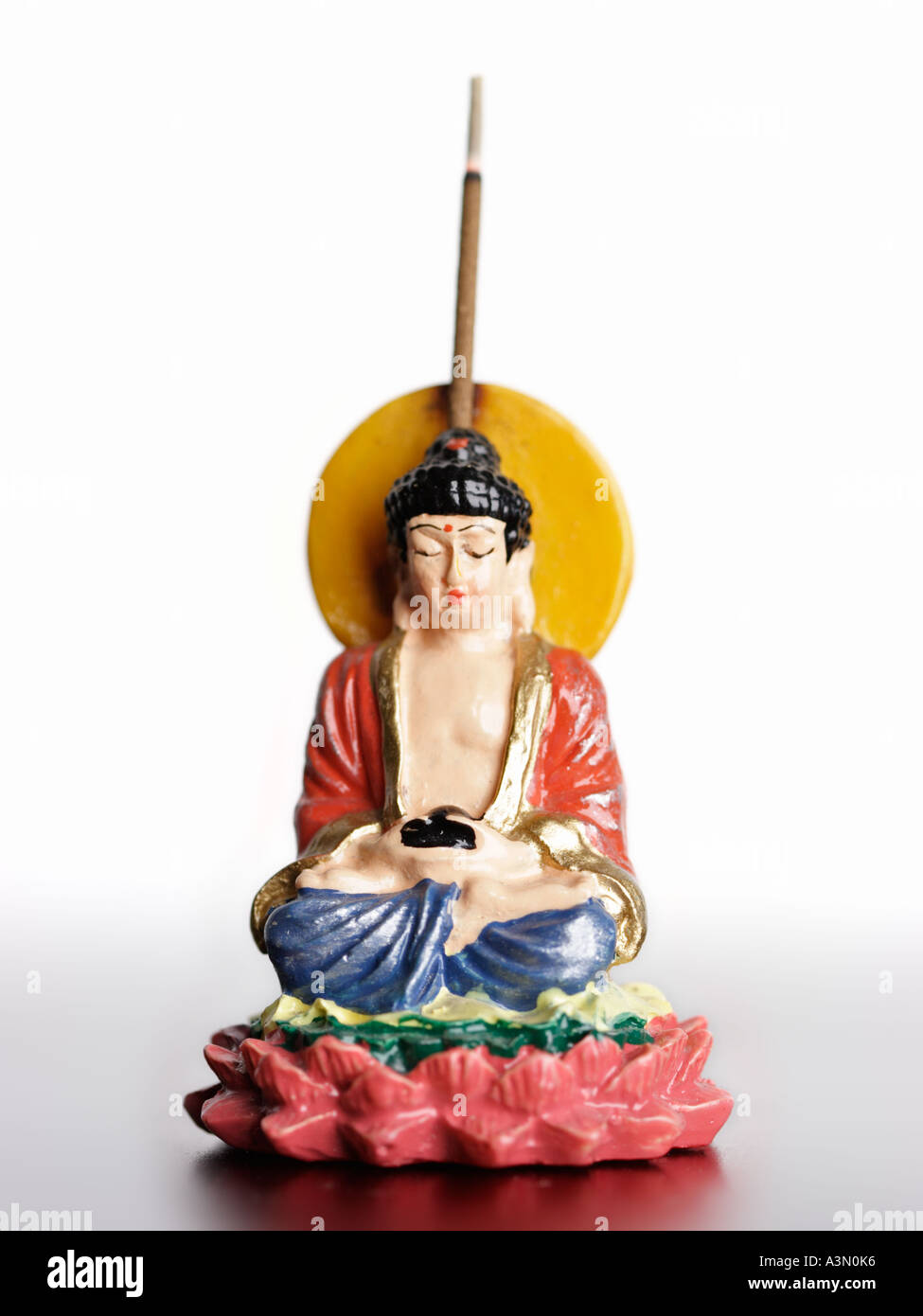 Buddha figure with burning joss stick on white background, focus on face Stock Photo