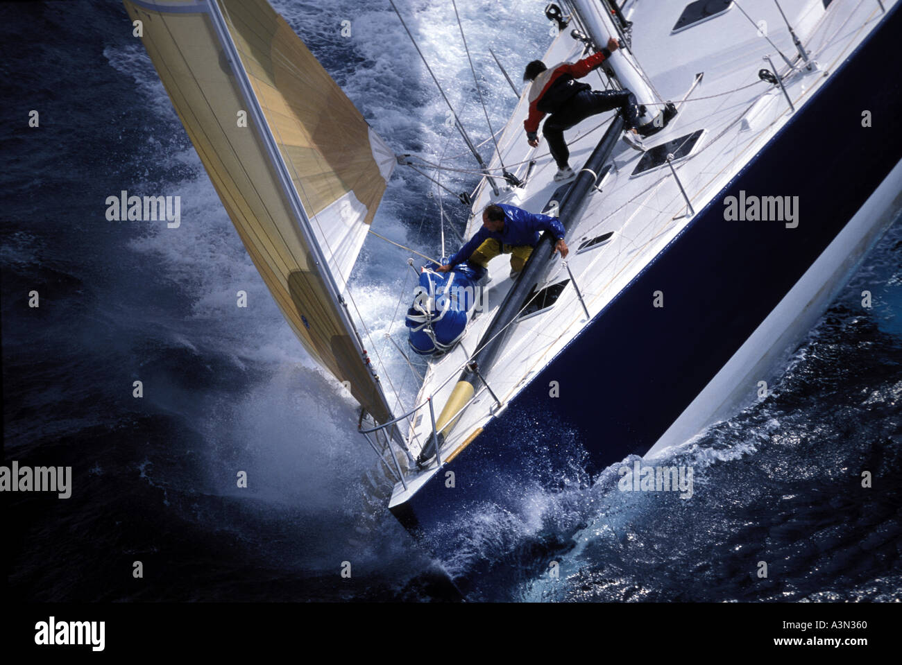 Two crew members of the foredeck of a maxi yacht in rough seas Stock Photo
