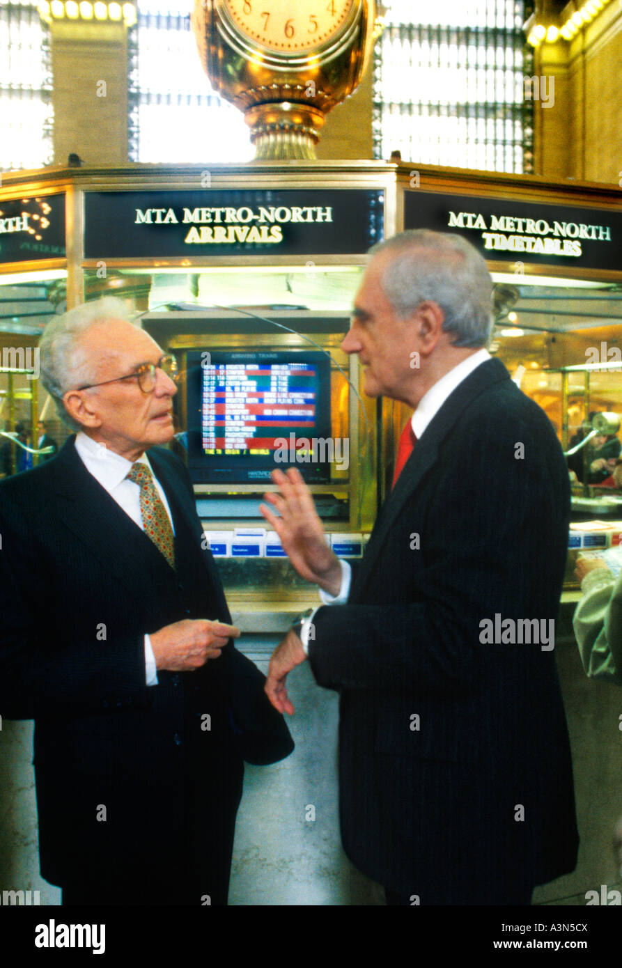 Two businessmen in animated conversation. Grand Central Station Terminal building under the clock. New York City, USA. Close-up Stock Photo