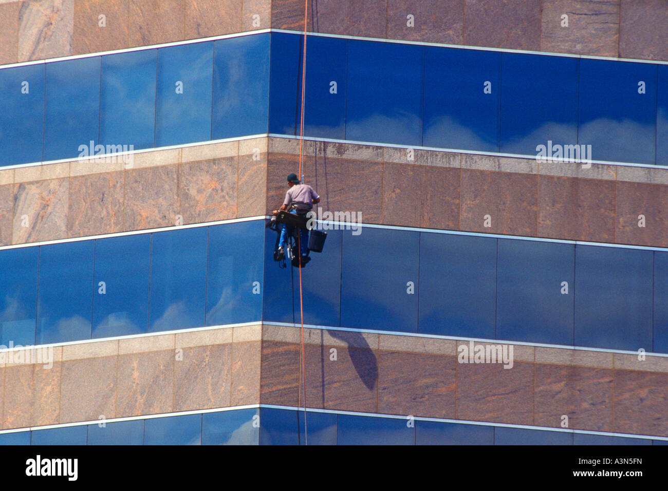 Window washer working on the outside of a modern skyscraper in Austin