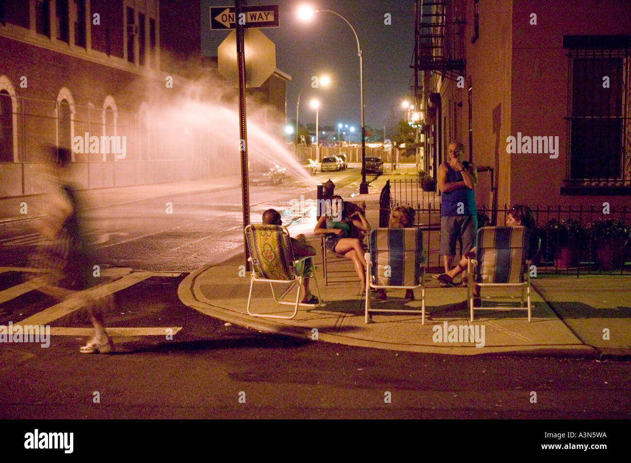 A Family Relaxes On Deck Chairs Near An Open Fire Hydrant On