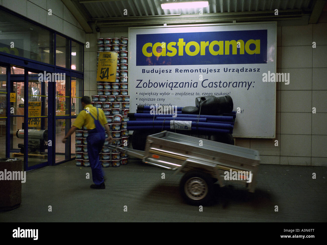 Worker with a trailer at the entrance to the home improvement store  Castorama, Poland Stock Photo - Alamy