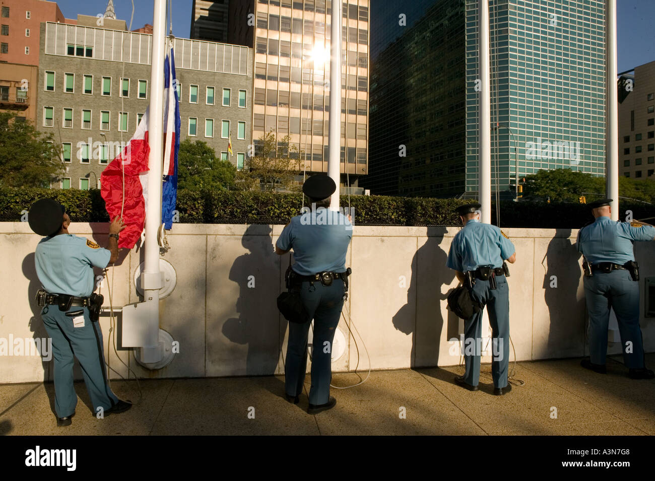 United Nations security guards raise the member states flags in front of the UN general secretariat building on 1st avenue in Ne Stock Photo