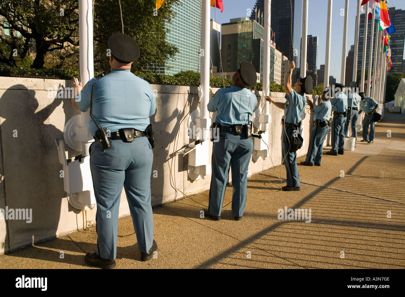 United Nations security guards raise the member states flags in front of the UN general secretariat building on 1st avenue in Ne Stock Photo