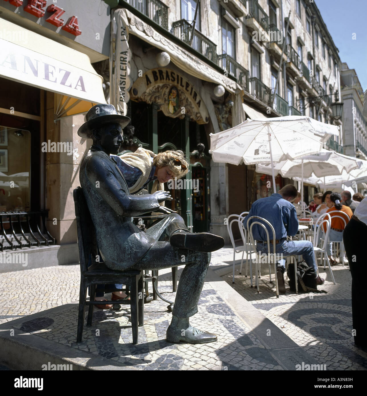 WOMAN LOOKING AT BRONZE STATUE OF POET FERNANDO PESSOA IN FRONT OF