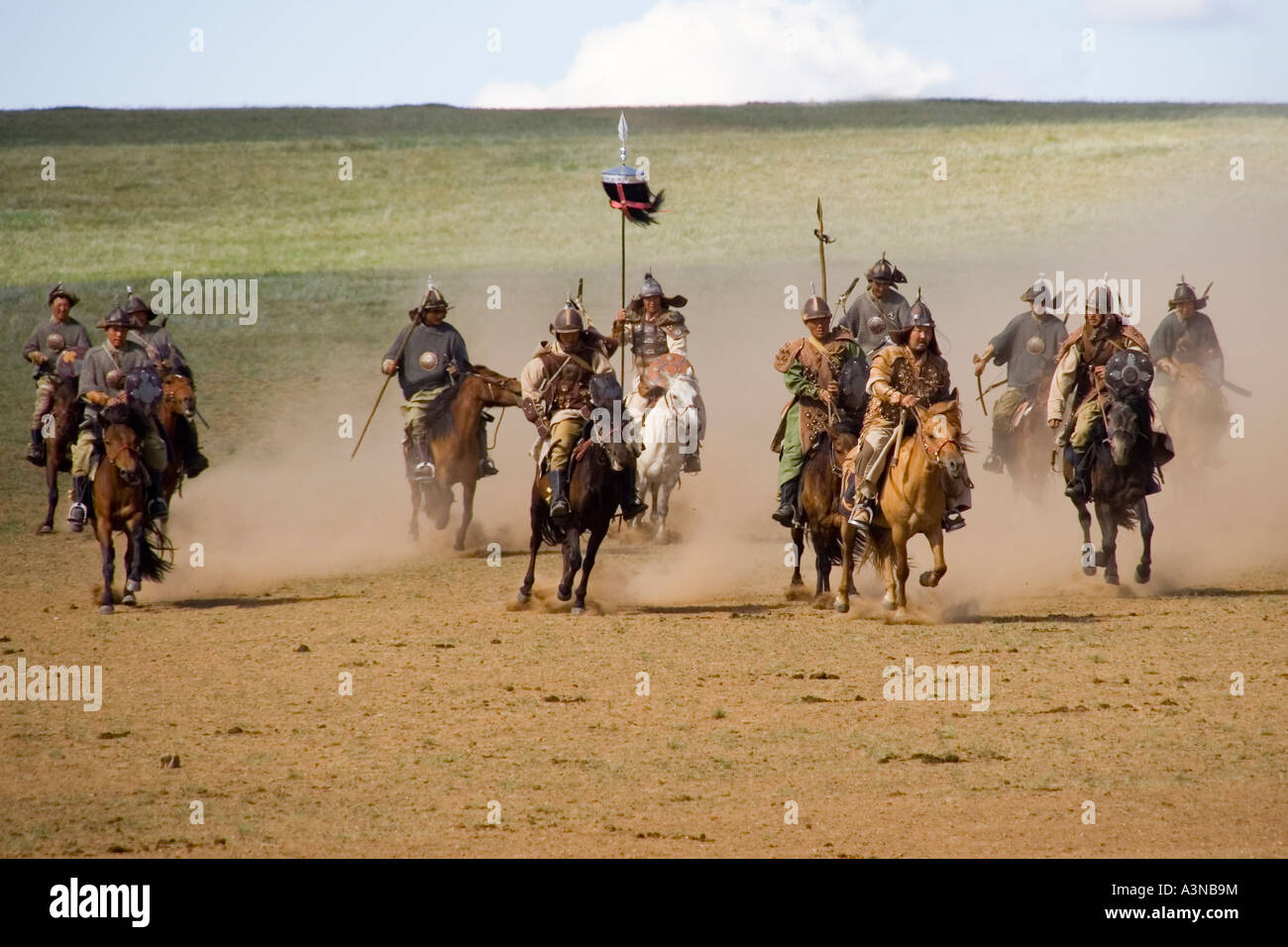 Mongolian cavalry charging into battle with weapons drawn Stock Photo