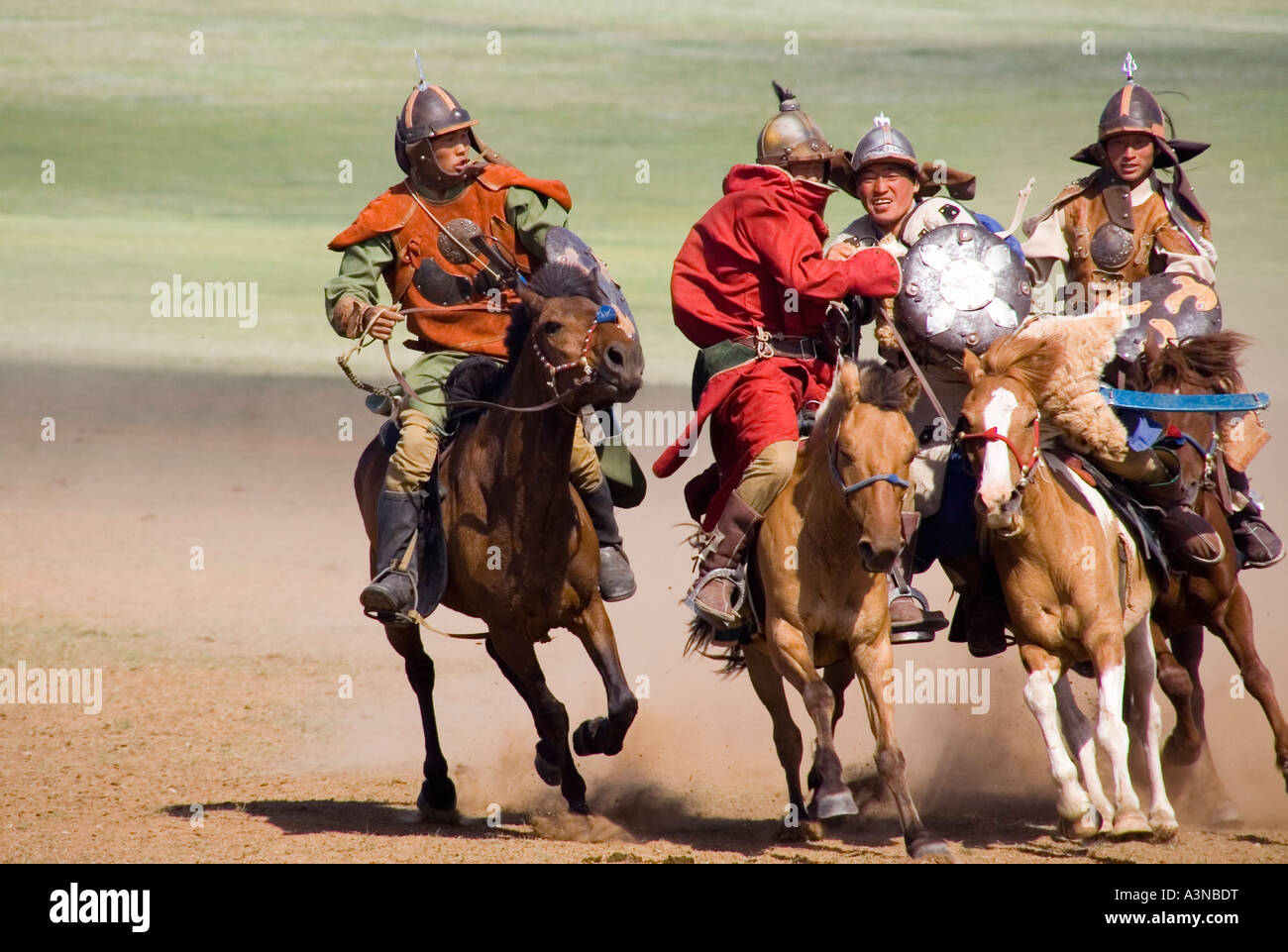 Four Armed Mongolian horsemen riding in close formation Stock Photo