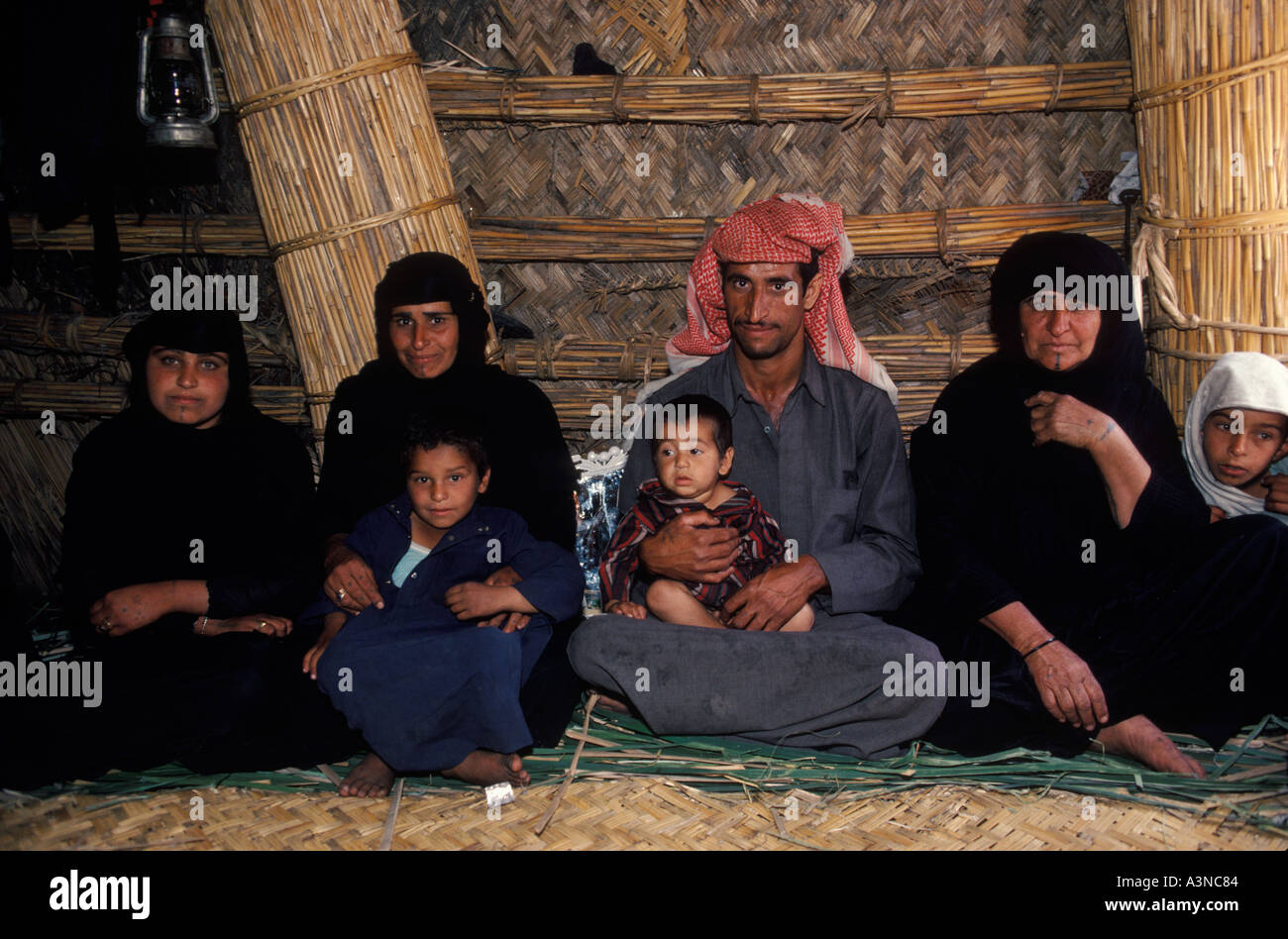 Polygamous family group husband two wives children and four children Marsh Arabs Iraqi 1984. Near Basra Southern Iraq. 1980s HOMER SYKES Stock Photo