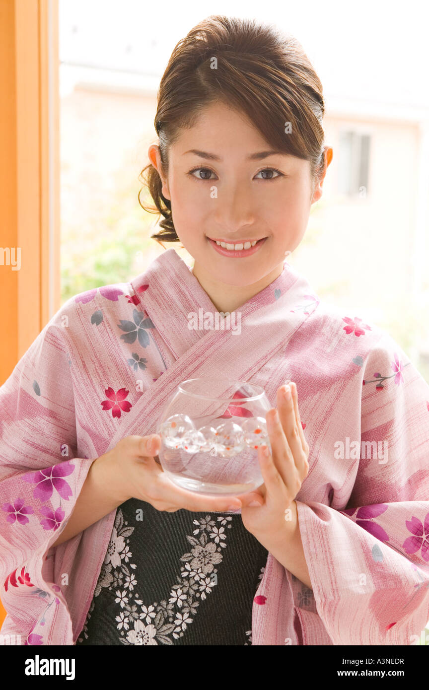 A young woman wearing yukata holding glass bowl Stock Photo