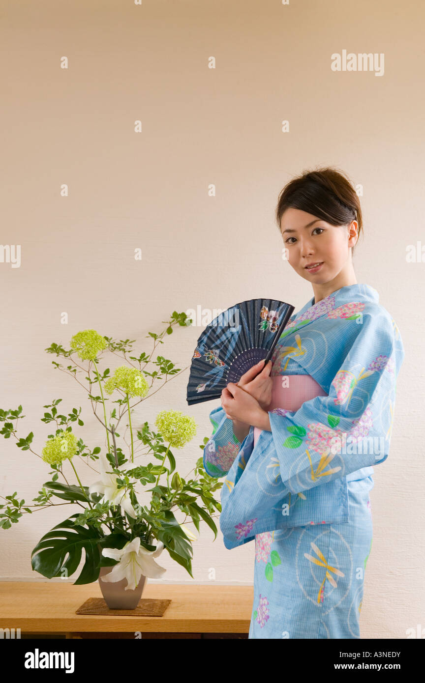 A young woman wearing yukata holding folding fan Stock Photo