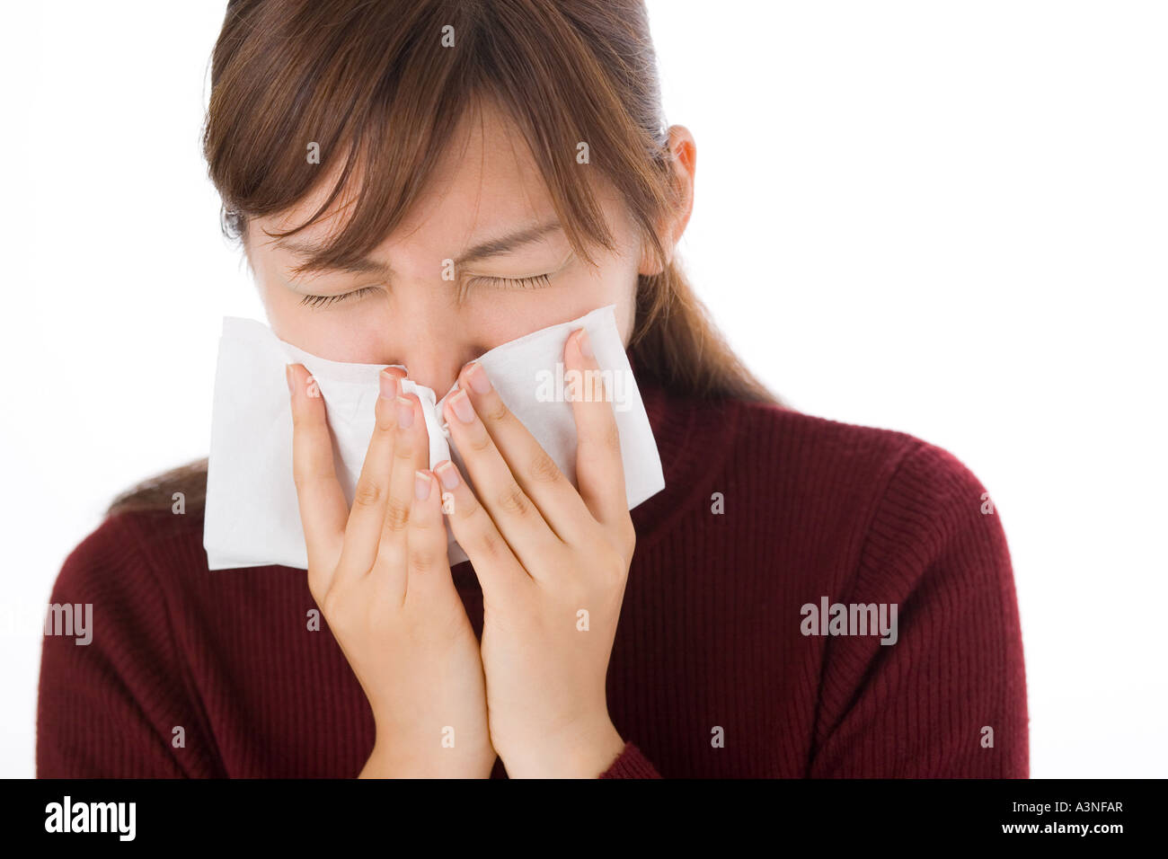 A young woman blowing nose on tissue Stock Photo - Alamy