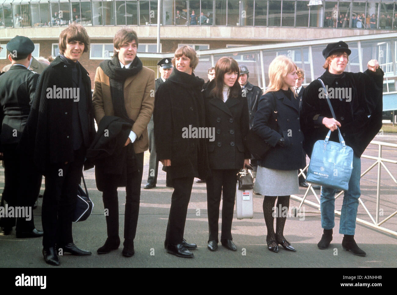 BEATLES leaving Heathrow to film HELP in 1965. From l: George, Paul, Ringo, Maureen, Cynthia, John Stock Photo