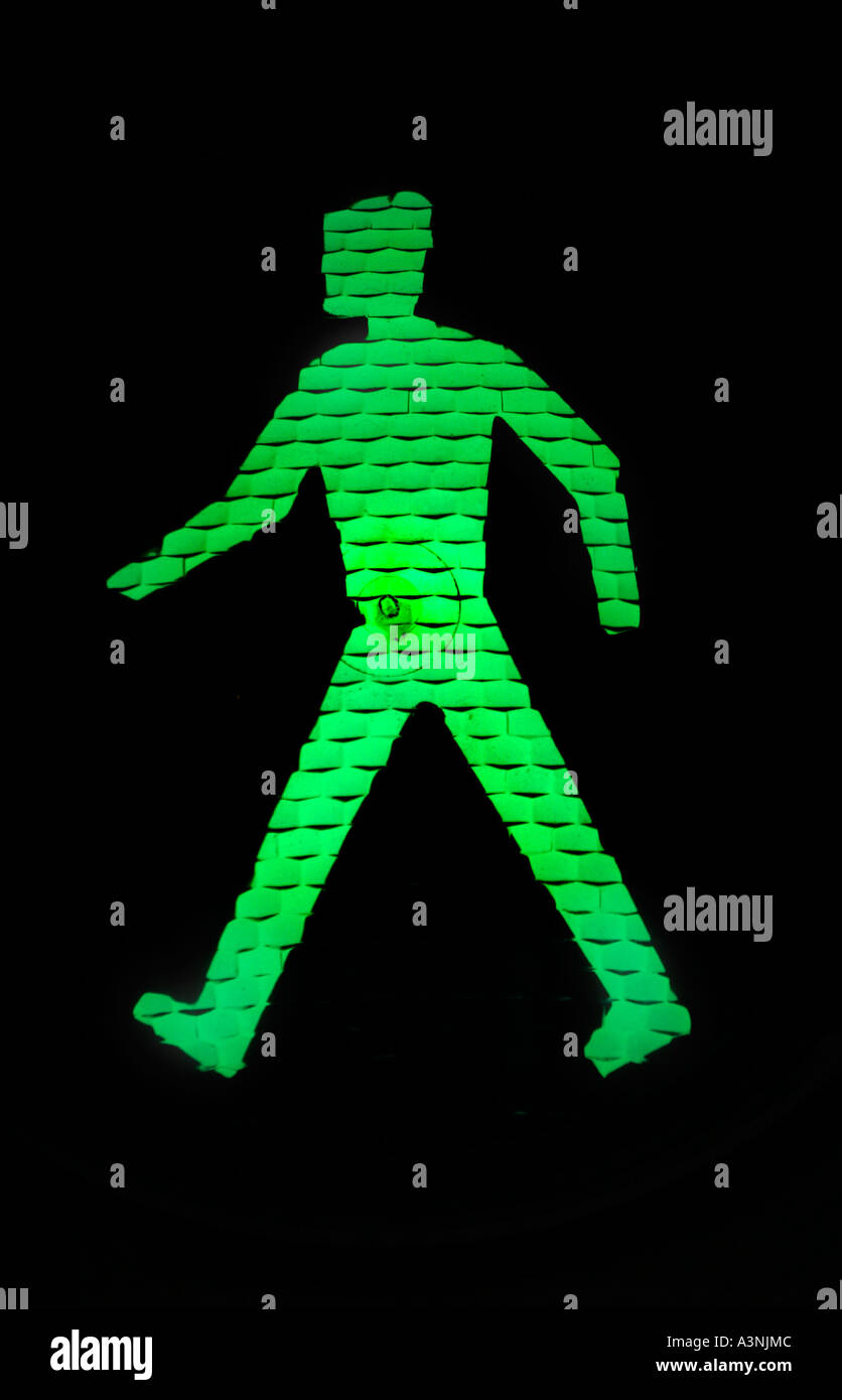 Man walking green go sign at traffic lights Stock Photo