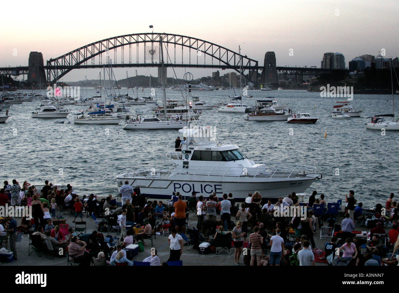 A Police Boat patrols Sydney Harbour as New Years Eve Revellers gather to watch the annual fireworks display Stock Photo