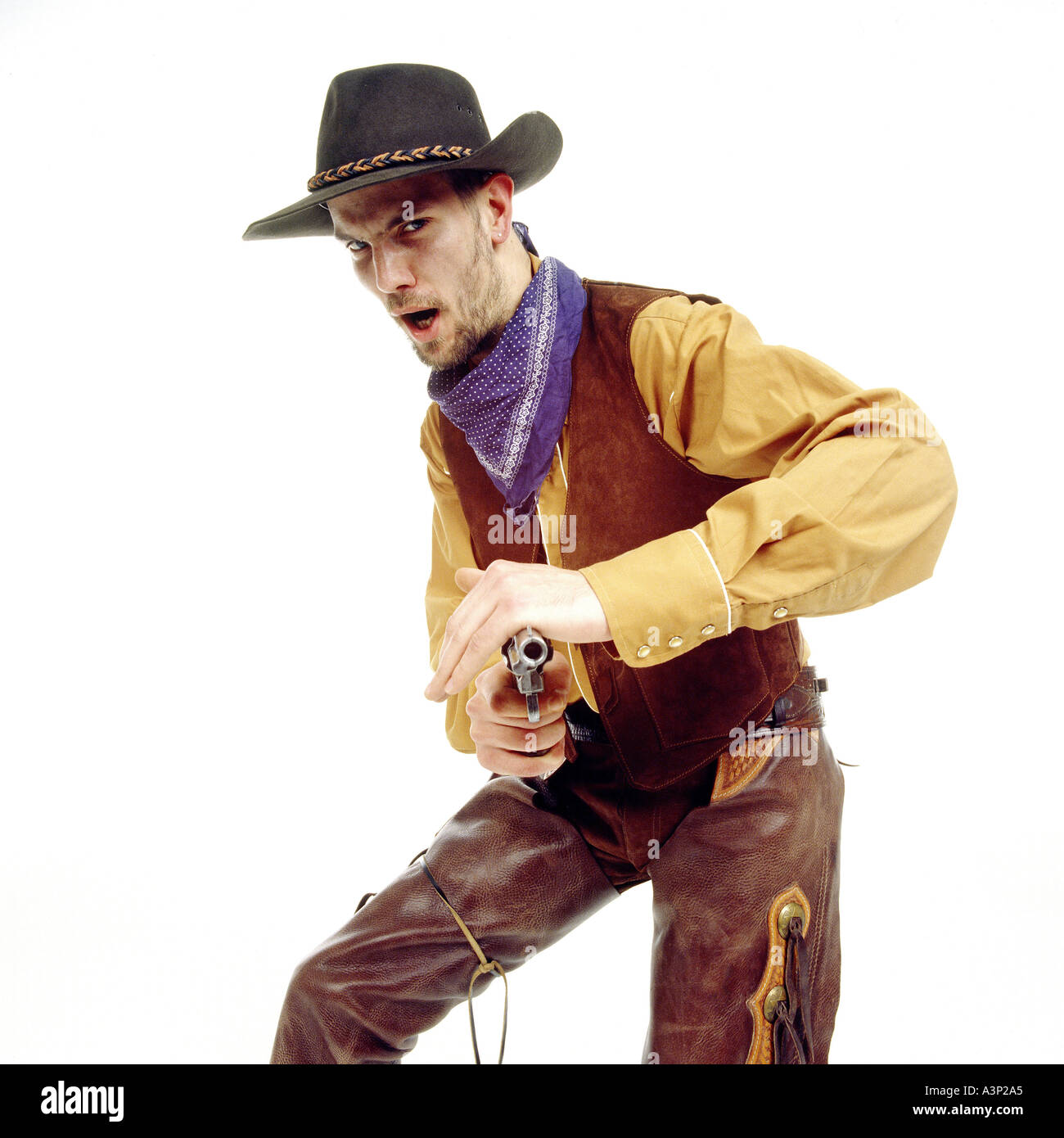 Young man dressed as cowboy, pointing gun, portrait Stock Photo