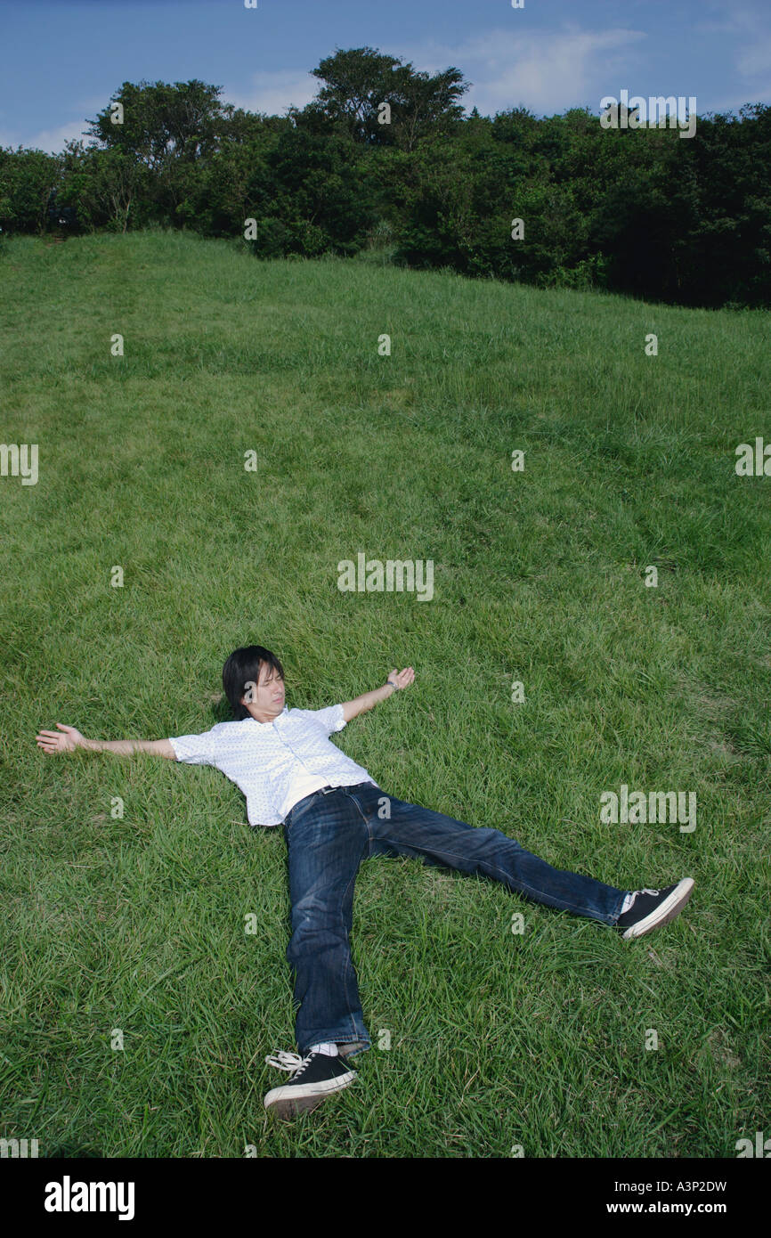 Layed Open A young man lying on grass with his arms and legs widely open Stock ...