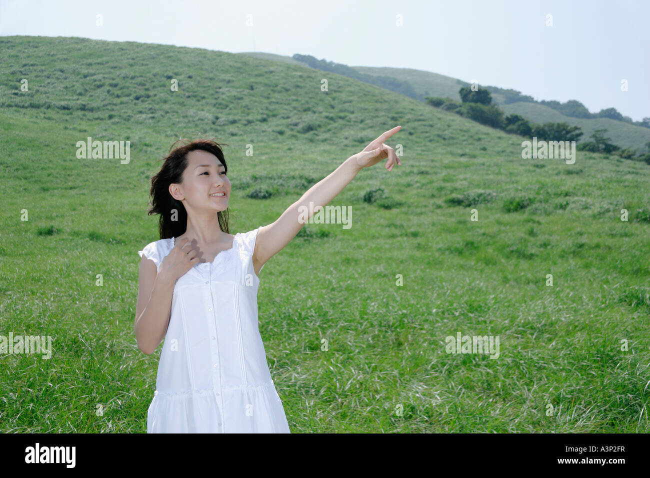 A young woman standing in field Stock Photo - Alamy