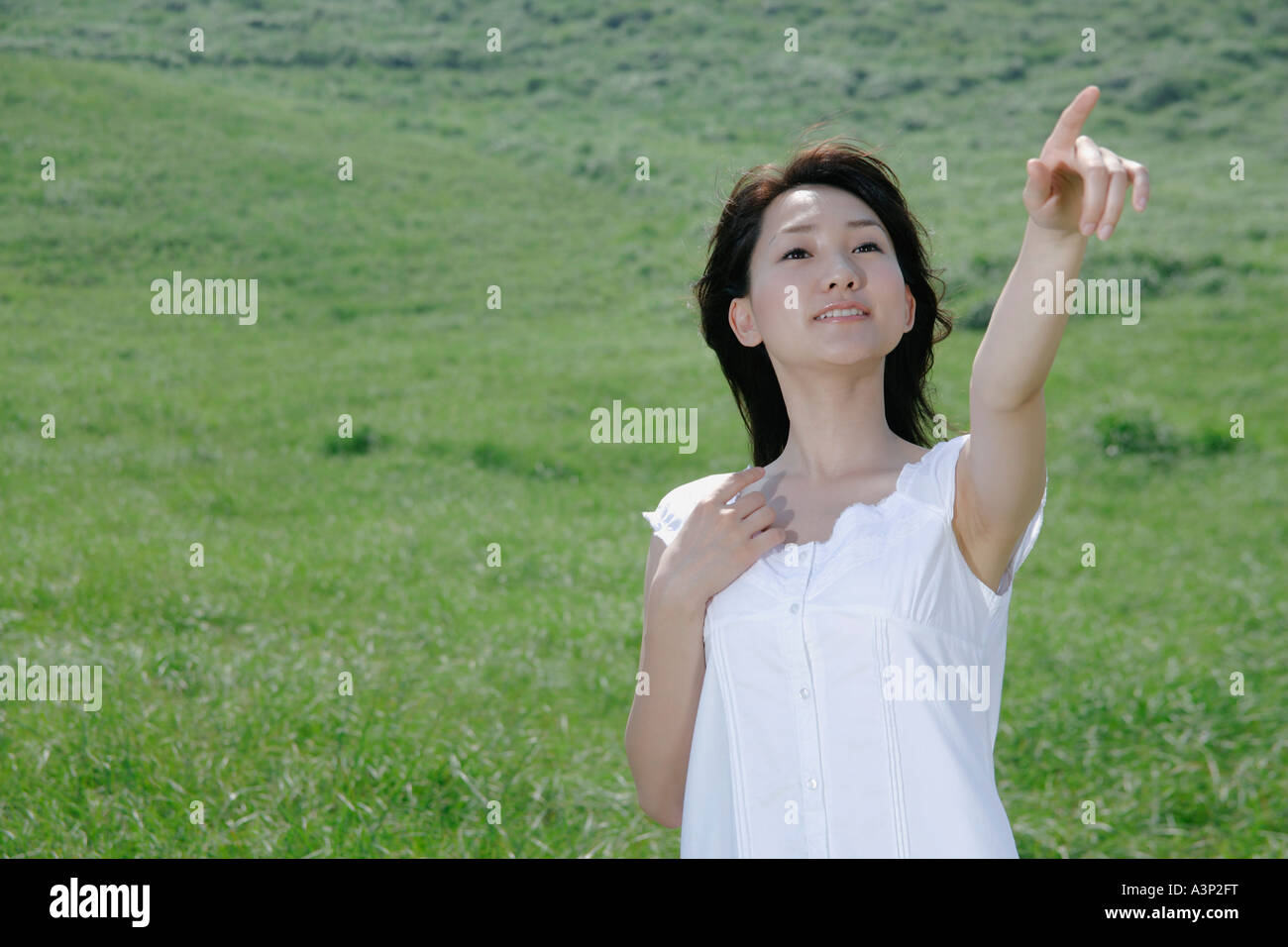 A young woman standing in field Stock Photo - Alamy